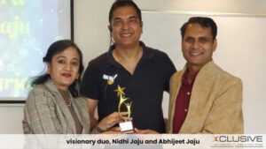 Nidhi Jaju and Abhijeet Jaju receiving an award with a colleague, smiling proudly.