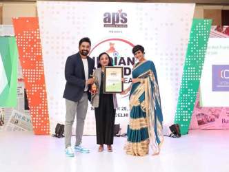 Three people on stage at an award event